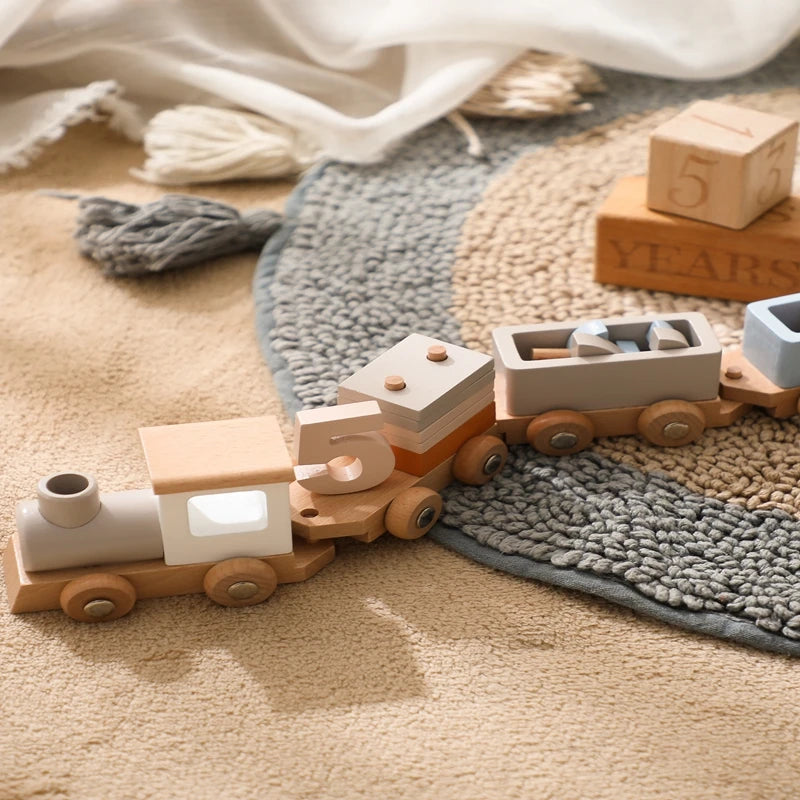 Wooden toy train with blocks and number 5 on a textured play mat