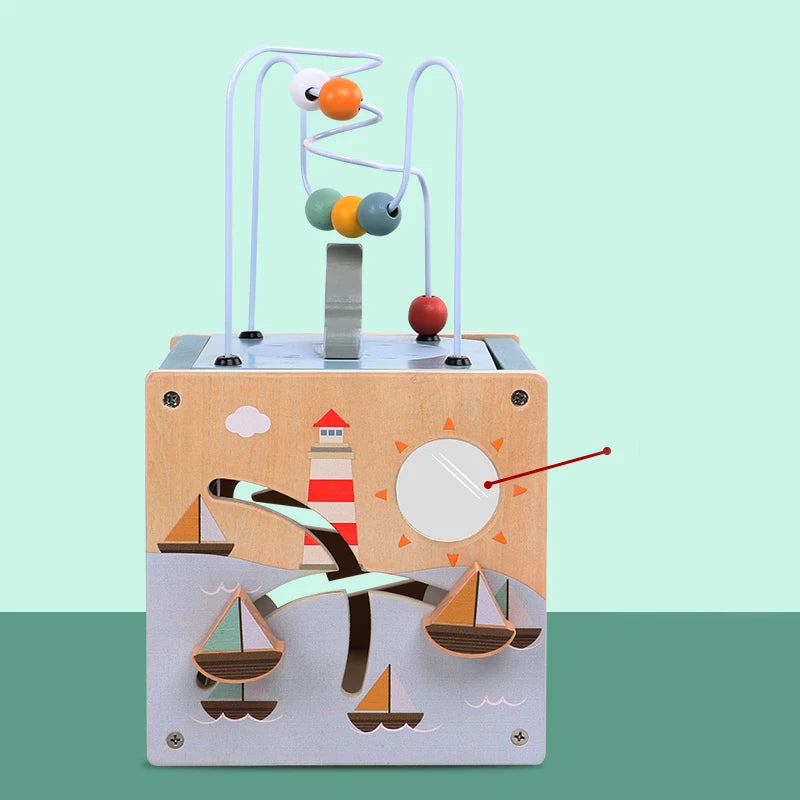 Wooden activity cube toy with bead maze, sailboats, lighthouse, and sun design