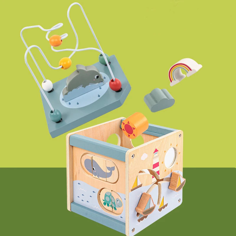 Wooden activity cube toy with bead maze, ocean animals, rainbow and sailboat designs
