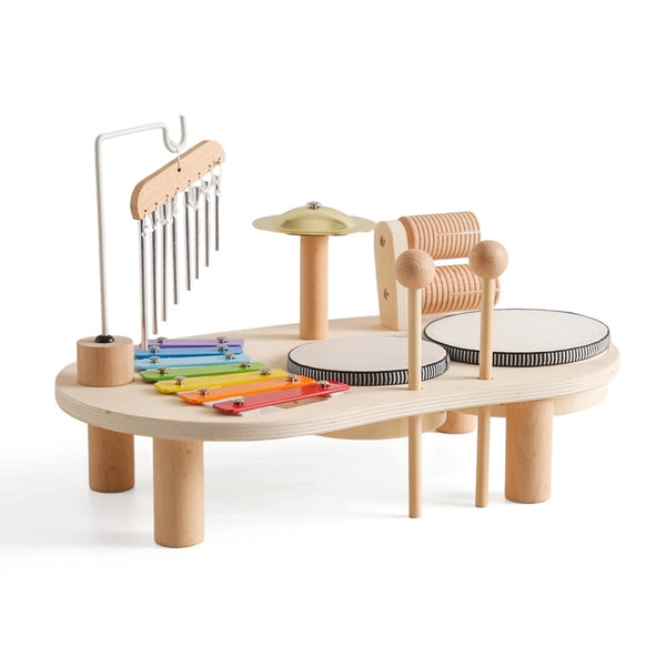 Wooden kids musical instrument set with drums, xylophone, chimes, and cymbal on table